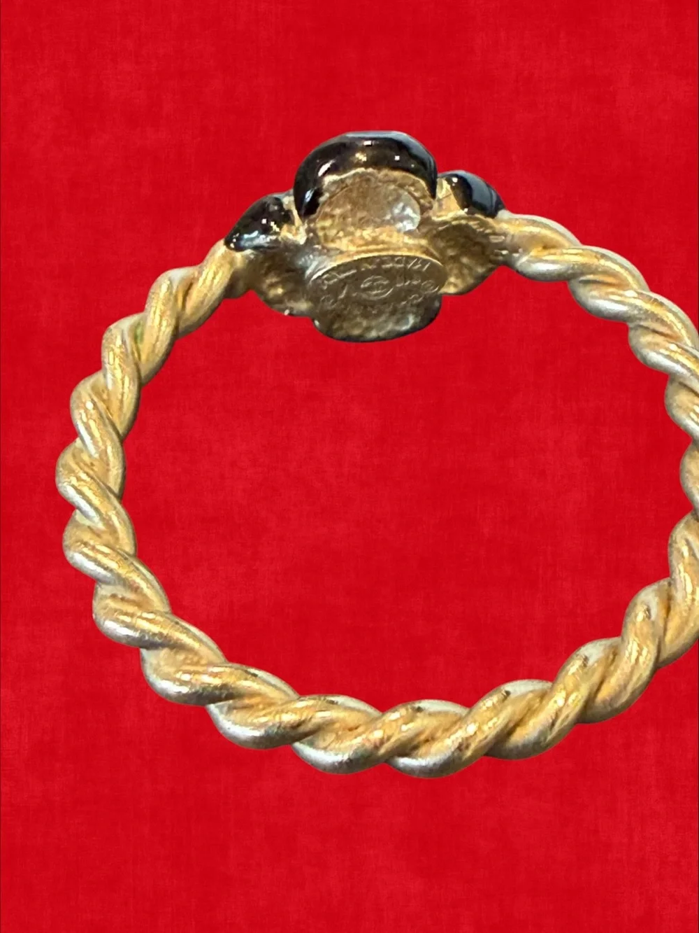 CHANEL Gold-Tone Twisted Band Ring with Black Floral Motif